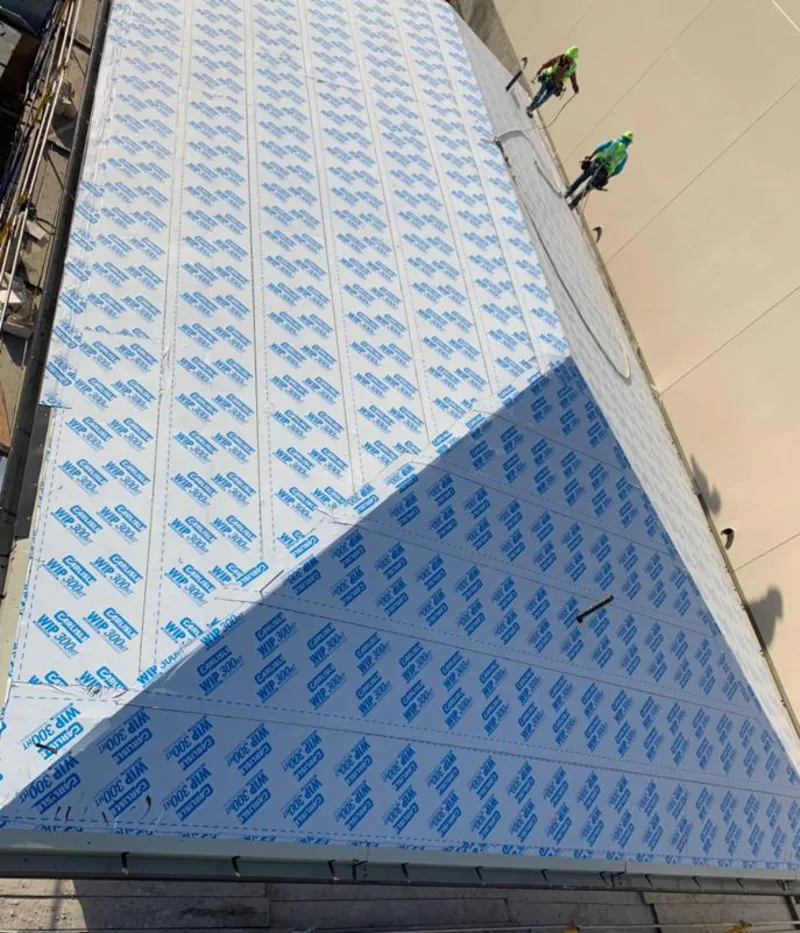 Professional roofers installing underlayment on a metal roof in Stockbridge